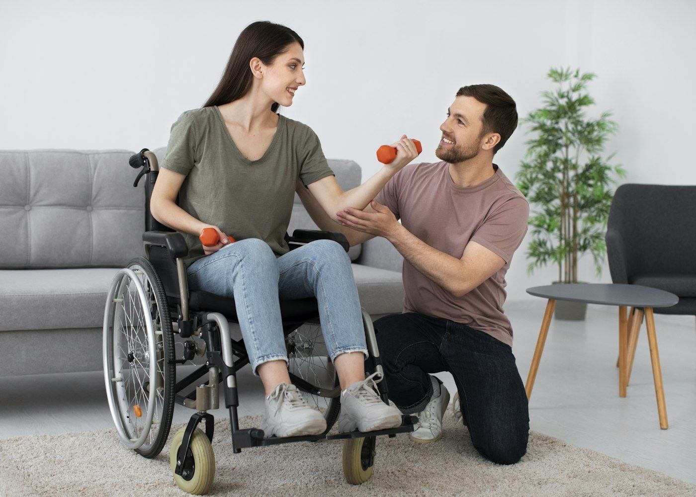 A caregiver supporting a young client during a strengthening exercise